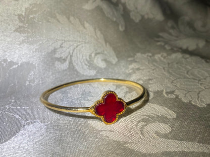 Minimal gold bangle bracelet with red four-leaf clover enamel charm