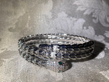Handcrafted silver-tone snake bangle bracelet with pavé crystal head and emerald eyes